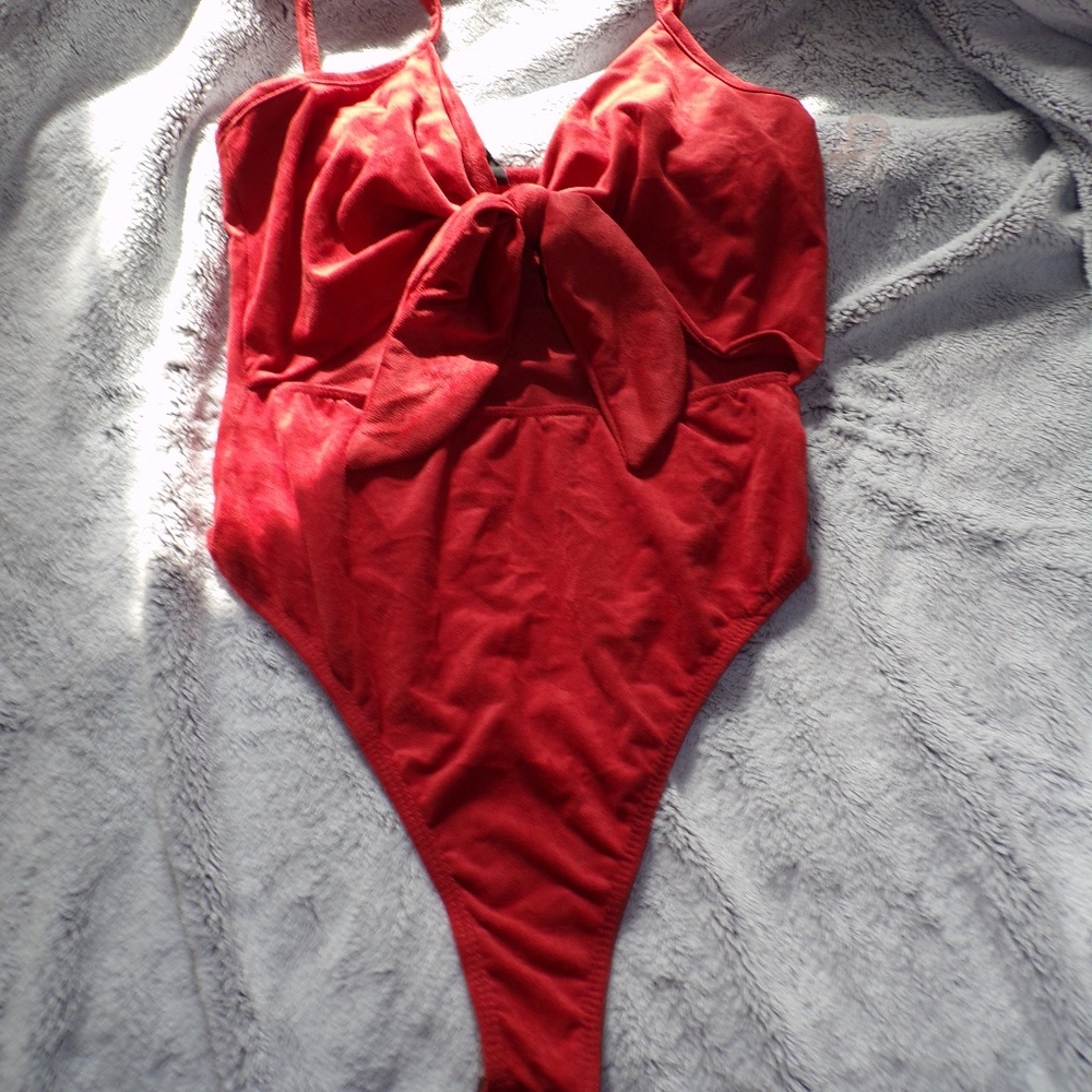 A red body suit with a mid drift opening